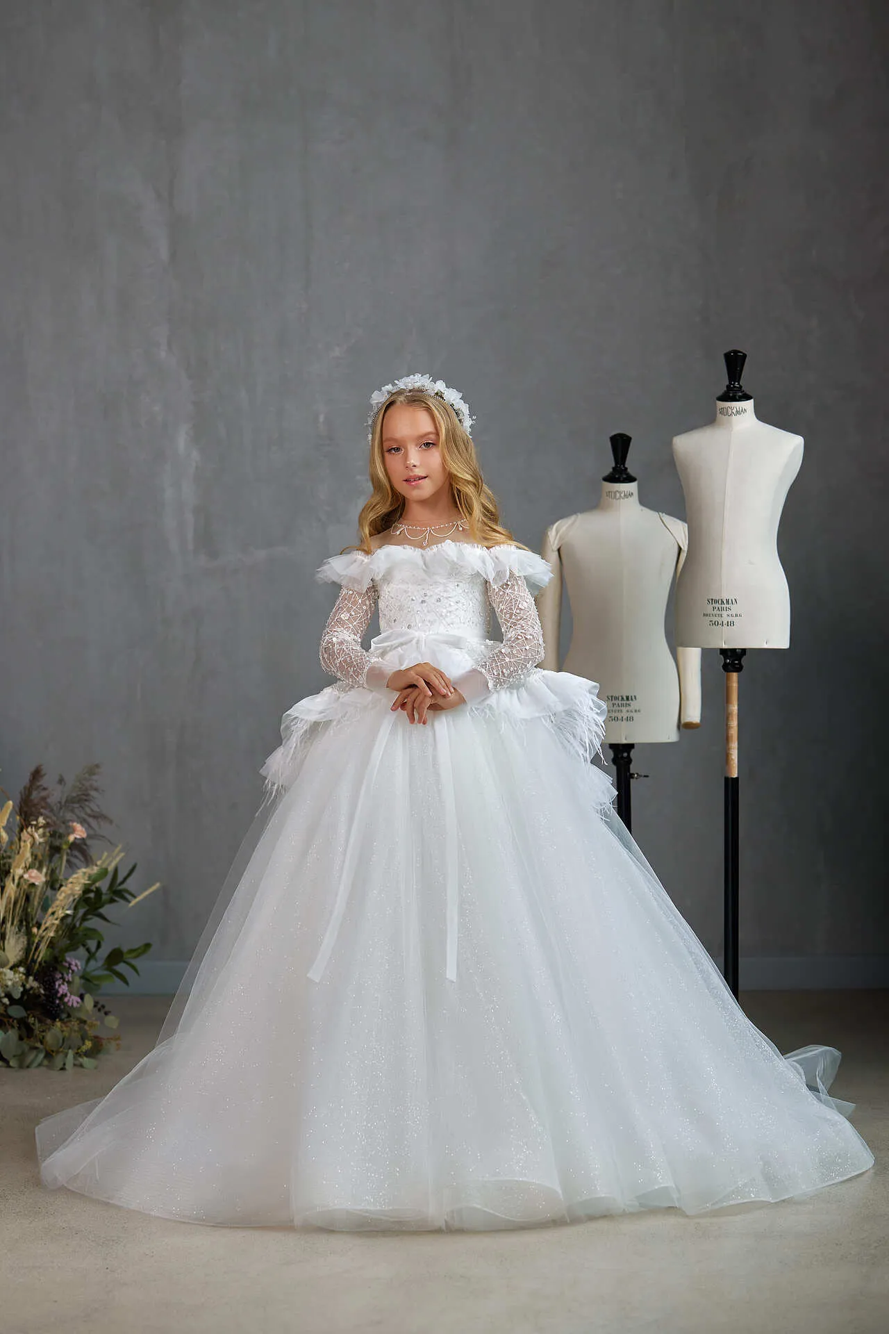 BOSTON – STRIKING OFF-THE-SHOULDER COMMUNION DRESS WITH RUFFLED FEATHER PEPLUM